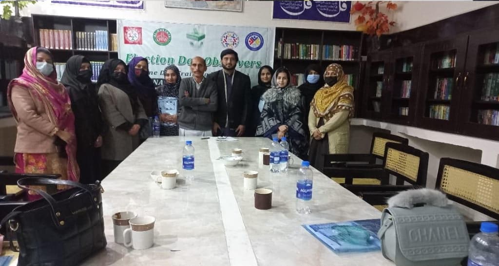 Group photo of election observer trainees around conference table